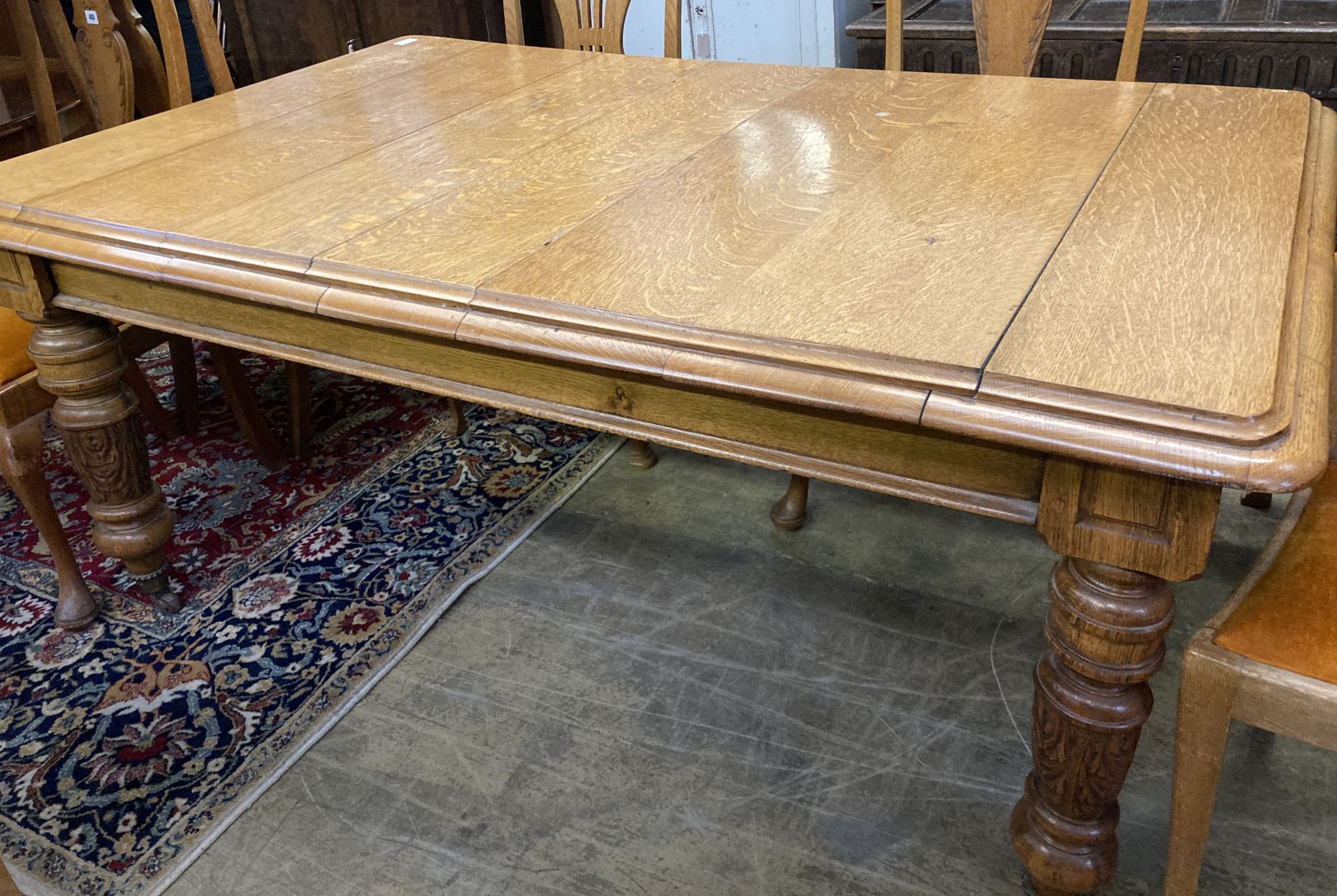 An early 20th century carved oak extending dining table, 294cm fully extended (three spare leaves), width 110cm, height 72cm